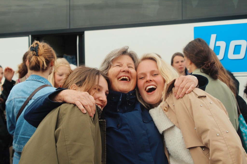 Groepsknuffel van jongeren en senioren bij vertrek